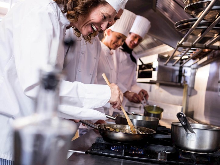 Cozinheiros junto a um fogão a gás natural