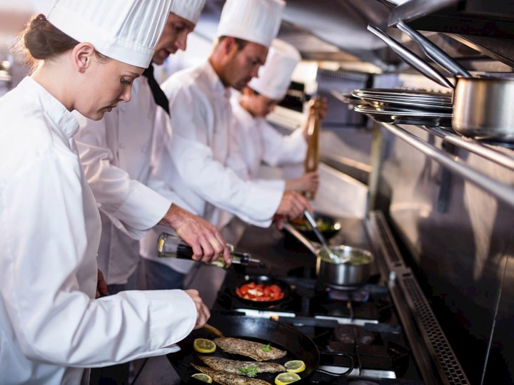 Cozinheiros junto a um fogão a gás natural